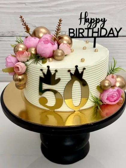 Another view of the 50th birthday cake, showing the beautiful combination of fresh flowers and metallic accents.