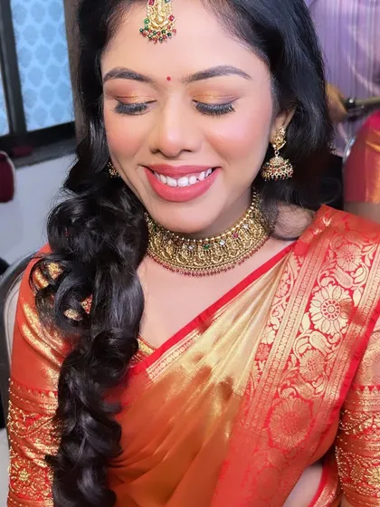 A beautiful bride with a happy smile. The makeup features a golden eyeshadow and a matching lip color, creating a warm and radiant look.