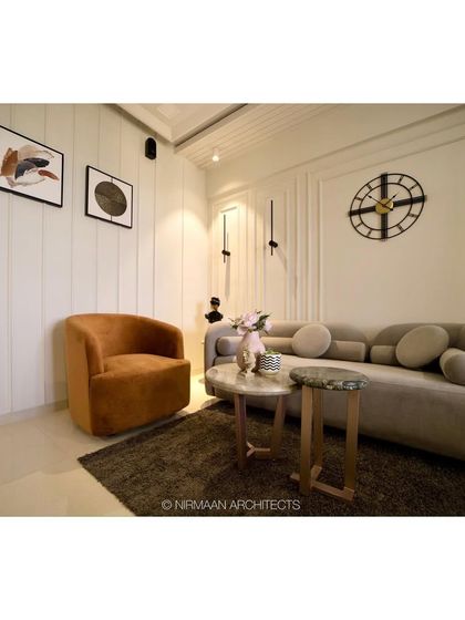 A modern classic living room designed for comfort and style. The curved sofa with bolster cushions and the unique armchair create a chic seating arrangement, perfect for conversations.