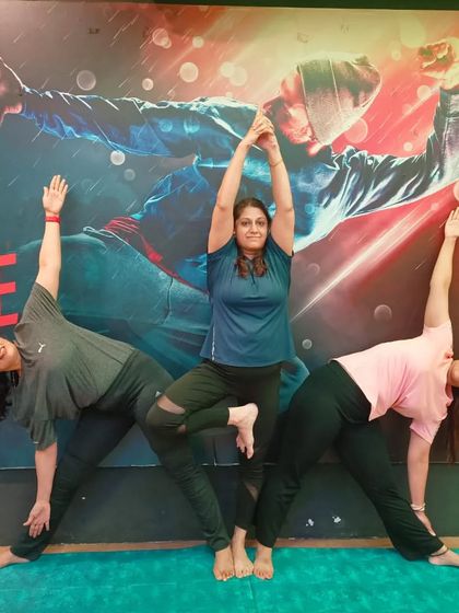 A beautiful group pose combining Tree Pose (Vrikshasana) and Triangle Pose (Trikonasana), showing the harmony and balance of our yoga community.