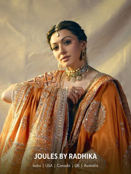 The beautiful Hansika Motwani in a stunning orange ensemble, her look crowned with our intricate polki and pearl choker and a delicate maang tikka.