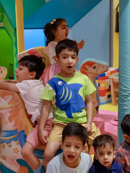 A group of excited children enjoying the mini carousel during a fun-filled unicorn birthday party.
