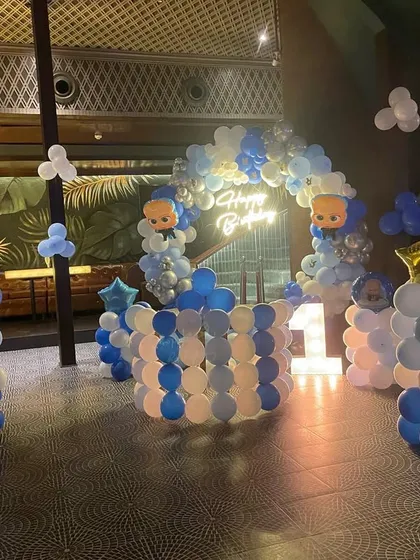 Another angle of the Boss Baby party setup, showing the lit-up marquee number '1' and balloon pillars. This theme is perfect for a stylish and fun celebration for a baby boy.