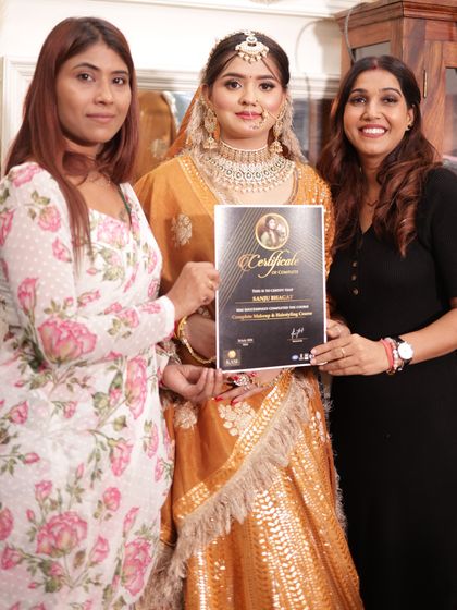 A student with her model, both looking stunning on certification day.