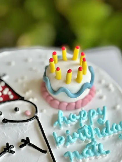 A close-up of the custom fondant mini-cake topper on this fun meme cake, showing the tiny, detailed candles.