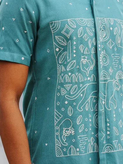 The front panel of our teal panther shirt, where modern, geometric panther motifs are hand-embroidered with precision. The design flows seamlessly across the placket, a detail only achievable with careful craftsmanship.