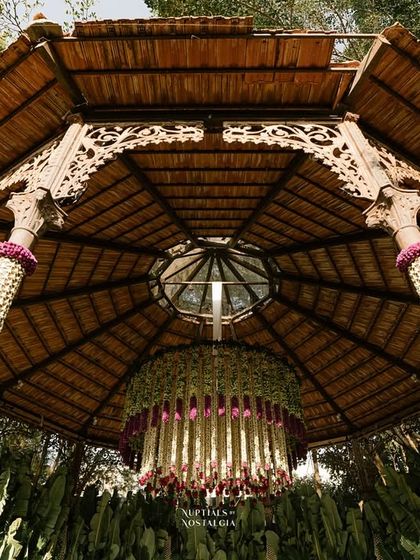 An upward view of the intricate woodwork of the bandstand, decorated with a floral chandelier.