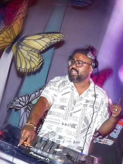 A dynamic, angled shot of me mixing at the console, with a large video screen and decorative butterflies in the background. It captures the artistic and technical sides of my work.