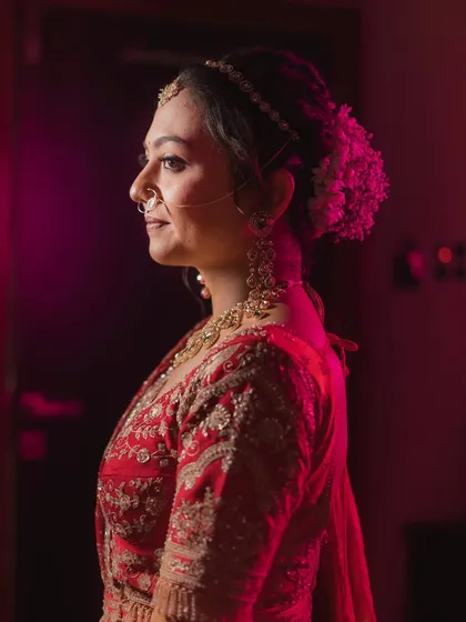 A side profile highlighting the elegant bun hairstyle adorned with fresh flowers.