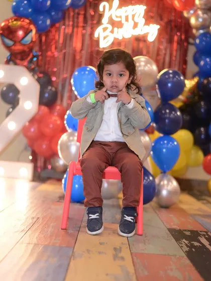 A cute shot of the birthday boy making a funny face at his party.