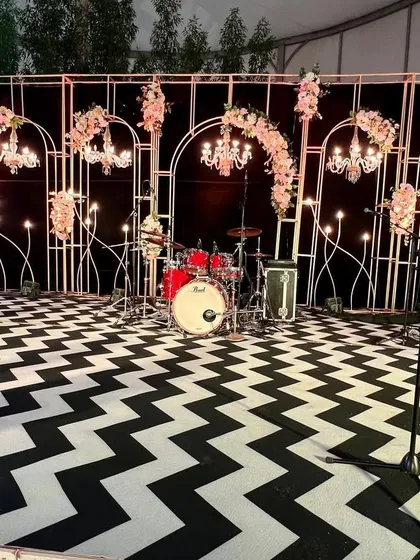 A 60th birthday bash doesn't have to be quiet. We designed this chic, modern stage for a live band, complete with a custom black and white chevron dance floor, elegant chandeliers, and floral arrangements. It was the perfect setup for a night of celebration.