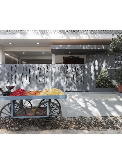 The home's modern facade provides a striking backdrop to the vibrant, traditional flower cart, a beautiful juxtaposition of old and new India.