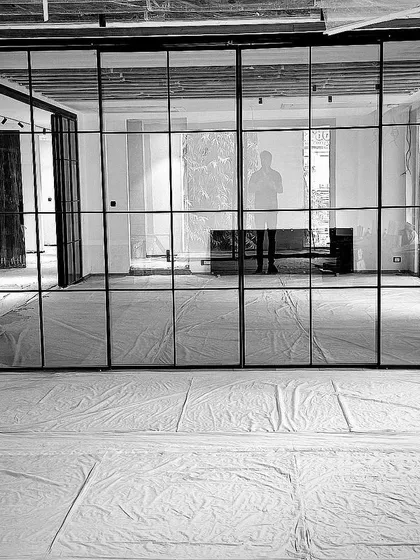 A large, metal-framed glass partition being installed in a Vasant Vihar residence. This element defines the space while maintaining an open, airy feeling.