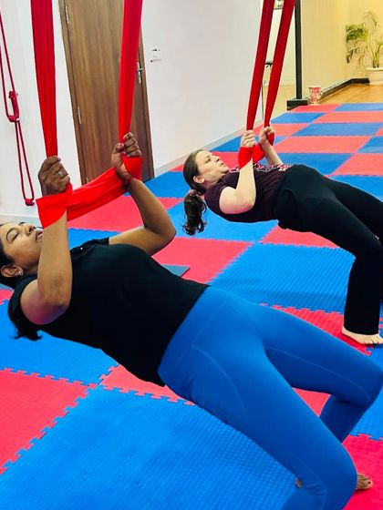 Using the hammock for resistance helps to build upper body and core strength. These students are practicing a suspended reverse plank, a challenging and effective conditioning exercise.
