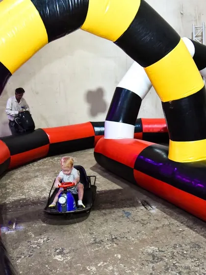A young child enjoying the inflatable go-kart track, showcasing a fun and active party entertainment option.