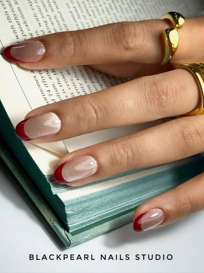 This trendy design features a glassy cat eye effect in a deep maroon shade, applied as a French tip. The magnetic depth and high-shine finish create a luxurious and modern update to the classic French.