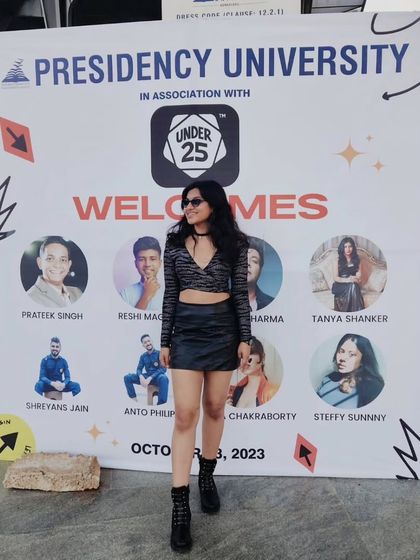 Posing in front of the welcome banner at the Under 25 Summit. It's always exciting to see my name and face alongside other talented performers.