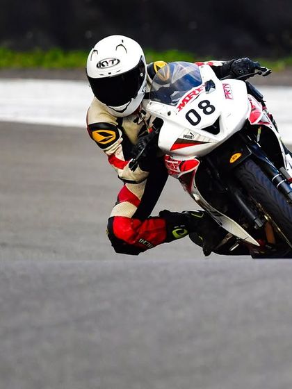 A close-up action shot of Meghana leaning into a corner, demonstrating the skills she developed with our team's support.