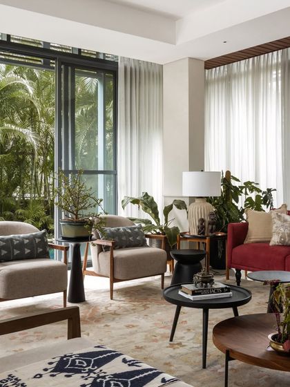 A neutral backdrop allows the furniture, art, and textiles to shine. Here, we balanced modern armchairs with eclectic side tables and patterned cushions.