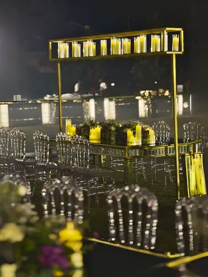A unique dining table setup with an overhead structure holding a row of candles. This modern take on a candelabra adds height and drama to the tablescape.
