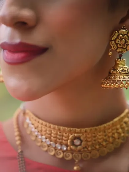 A close-up on the gold choker and jhumka, perfect for showcasing the craftsmanship of the jewelry.