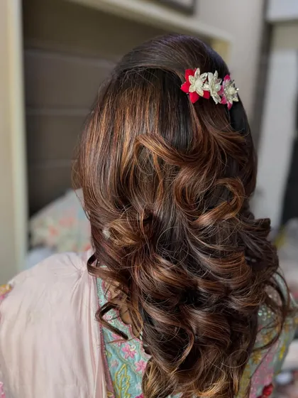 A closer view of the bouncy, blow-dried curls. You can see the texture and dimension in the hair, with highlights catching the light beautifully. This is a great party hairstyle for medium to long hair.