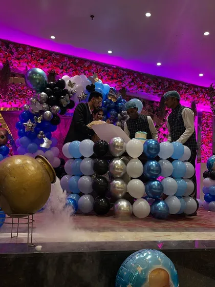 A candid moment from the event, showing the family at the decorated stage with a dry ice effect.