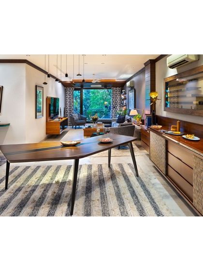 The boomerang-inspired dining table at Treetops, paired with a custom buffet counter. This view showcases how we design spaces for flow, where each piece of furniture complements the other to create a cohesive and functional living area.