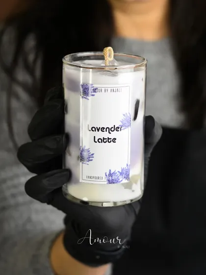 The soothing Iced Lavender Latte candle, held in hand to show its beautiful layered detail. A perfect candle for a calm evening.