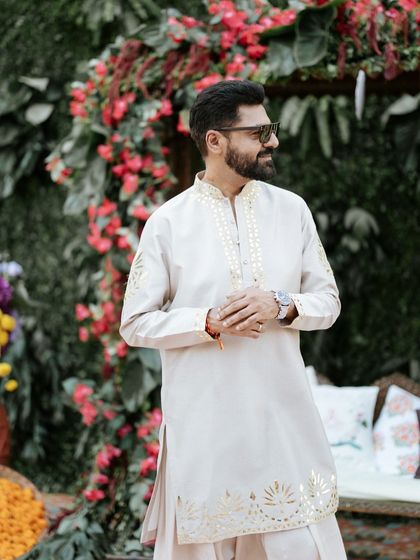 A candid moment of the groom, sunglasses on, enjoying the festive atmosphere of his outdoor Haldi event.