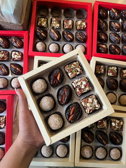 We create custom wedding favors to add a sweet touch to your special day. This image showcases a variety of our healthy Indian sweets, including stuffed dates and nut-filled delights, elegantly boxed for guests.