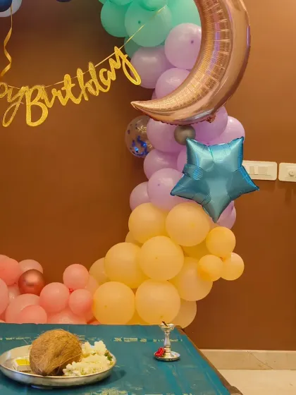 A celestial-themed home decoration for a 4th birthday, featuring a crescent moon balloon and pastel colors to bring the moon and stars indoors.