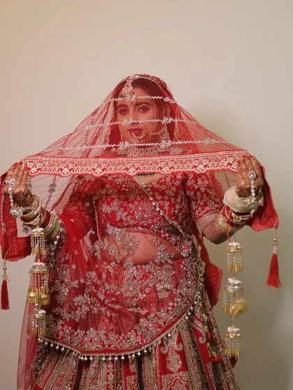 A beautiful shot of my bride Sakshi under her veil. The red lehenga, the jewelry, and the makeup all come together to create a picture-perfect bridal moment.