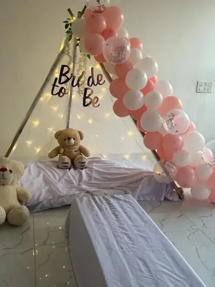A cute and cozy teepee tent setup for a 'Bride to Be' celebration, decorated with balloons and fairy lights.