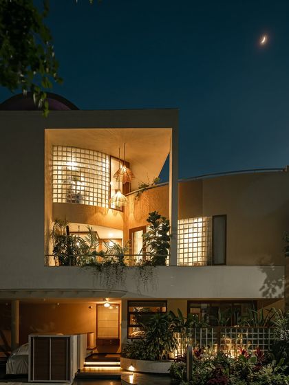This series of images shows how the home's exterior transforms from day to night. The glass block walls, which provide privacy during the day, become luminous features in the evening, creating a warm and inviting aura.