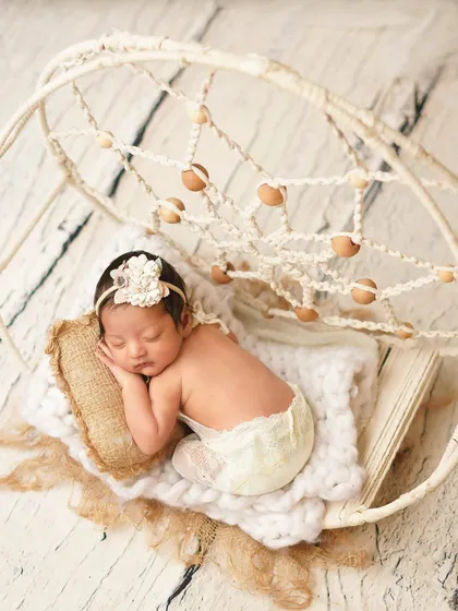 A wider view of the dreamcatcher theme, with the baby posed as if she's part of the beautiful macrame art.