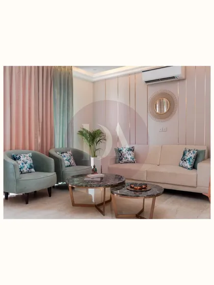 A full view of the living area featuring our bespoke furniture. The pastel green armchairs, beige sofa, and nested marble coffee tables were all selected and placed to create a harmonious and elegant setup.