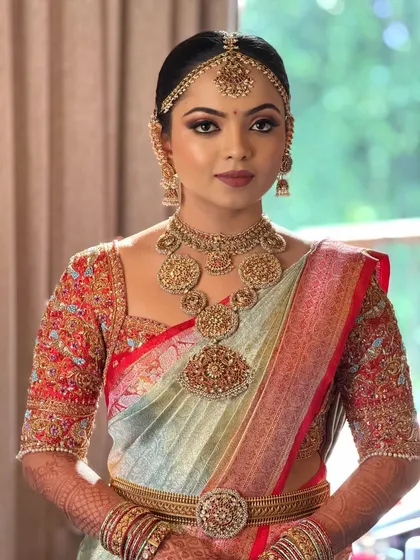 A close-up portrait of the bride, focusing on her stunning temple jewelry and the sharp, defined eye makeup that makes her eyes pop.