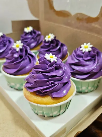A close-up of the rich purple buttercream swirl on these strawberry-flavored cupcakes.