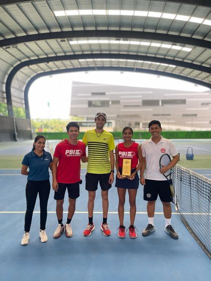 A smaller group of players and coaches celebrating a doubles title, highlighting the close-knit bonds within our training groups.