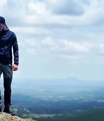 A solitary moment on the edge of Shivagange hill, showcasing the vastness of the view.