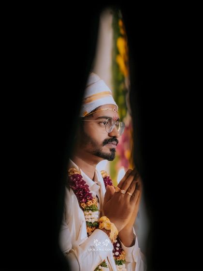 An artistic, framed portrait of the groom in prayer, capturing a moment of quiet devotion.