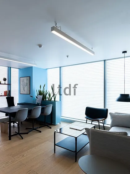 This office cabin exudes a classy ambiance with its muted, blue-toned color palette. Flooded with natural light from expansive windows, the workspace blends functionality with a refreshing and uplifting environment, promoting focus and creativity.