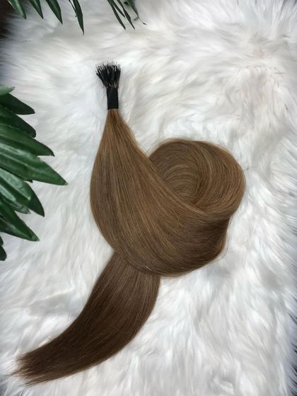 A beautiful bundle of light brown I-Tip extensions, artfully arranged to showcase their silky texture and color.