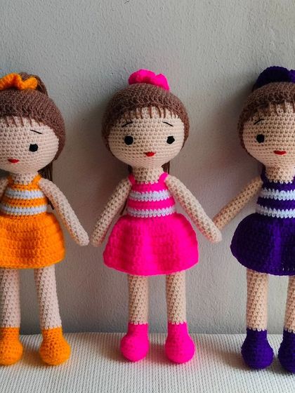 Three friends in matching striped dresses, but in different colors: orange, pink, and purple.