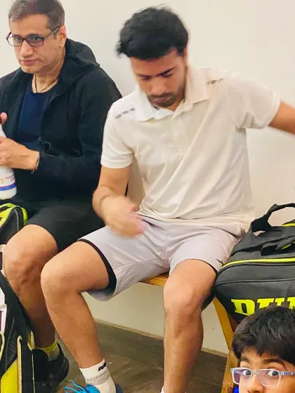 A candid moment on the bench, preparing for my next match. The grind never stops, even for the coach.