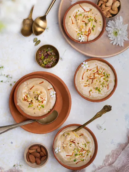 A beautiful flatlay of payasam (kheer) in earthen bowls, garnished with saffron and pistachios. This shot was styled for Janmashtami, with a bright and airy feel to celebrate the occasion.