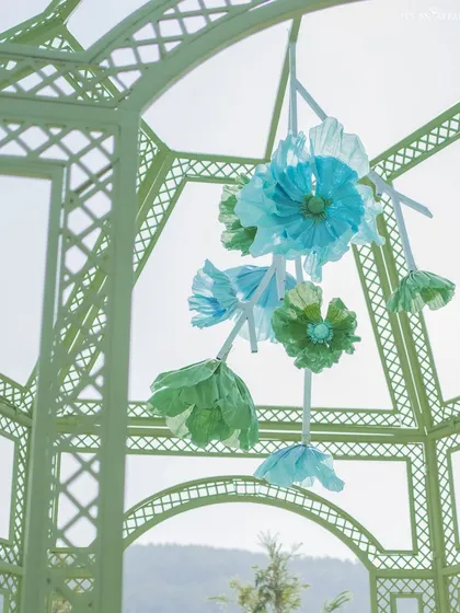 A close-up of the delicate, handcrafted paper flowers hanging inside the mandap, adding a touch of artistry and whimsy to the structure.
