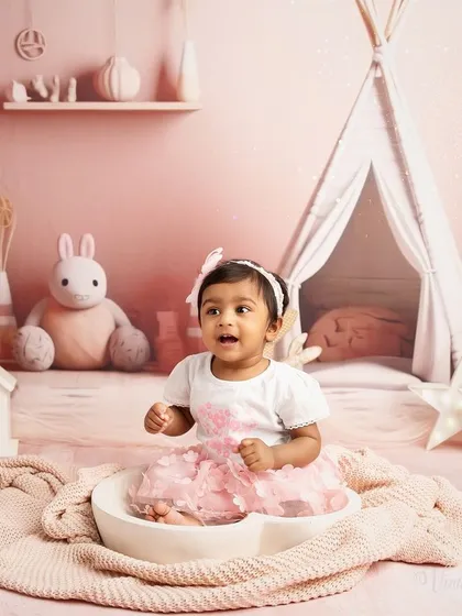 A moment of pure excitement. This toddler portrait captures a baby's joyful expression as she sits in a bowl, part of a playful and imaginative studio session.