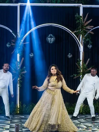A wide shot showing the full effect of the bride's solo with her backup dancers and dramatic stage lighting. I can help coordinate group elements to make your solo performance even more impactful.